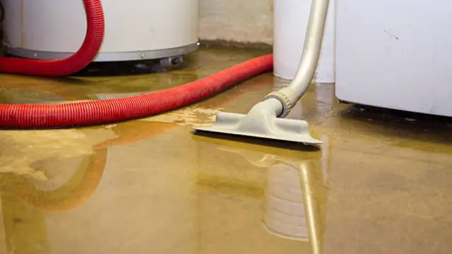 Wet vacuum with a red hose pulling water off a floor